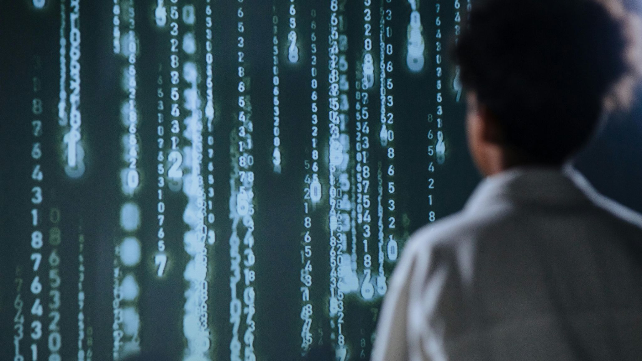 Person facing a big screen with numbers displayed