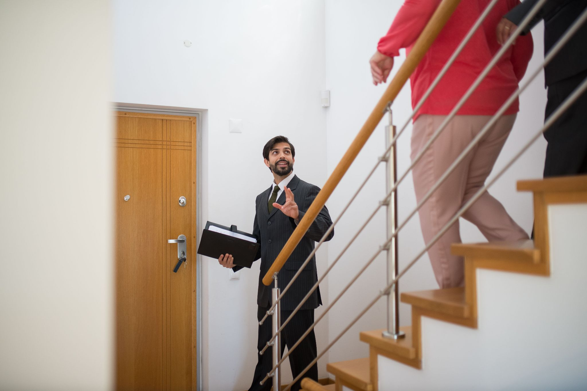 Property manager on a routine inspection walking downstairs with tenants