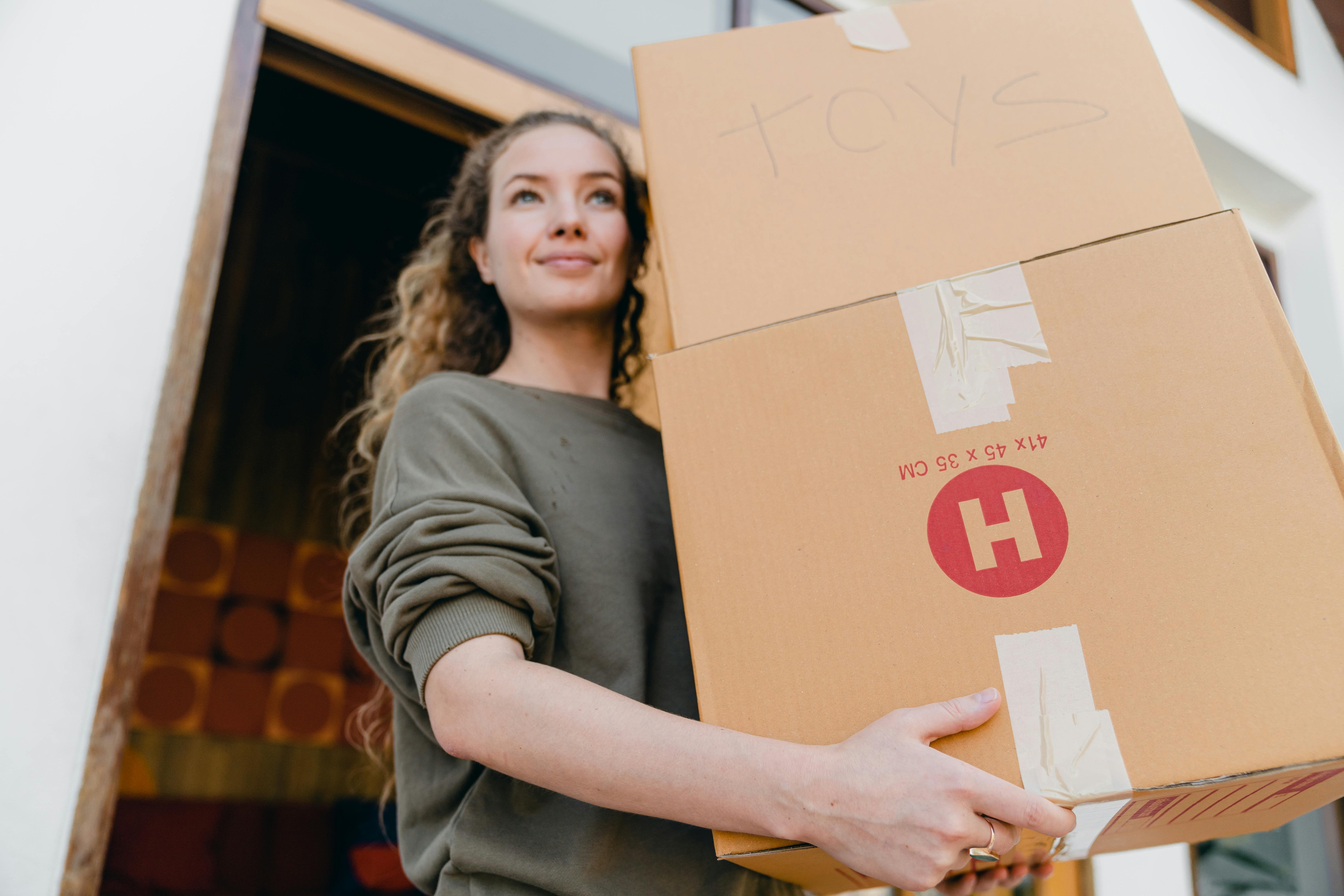 woman holding a moving box in a doorway